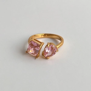 Detail of 18k gold plated open ring featuring pear and radiant cut pink zircon stones