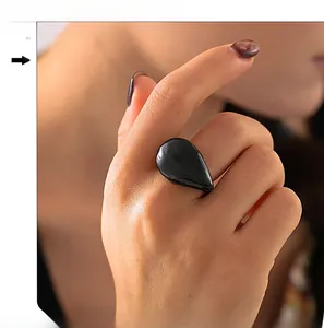 Detailansicht eines minimalistischen, 18K vergoldeten Tropfenrings mit schwarzem Harz