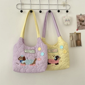 Close-up of quilted tote bags featuring dog embroidery and colorful button details
