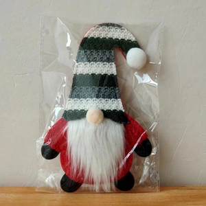 Close-up of Christmas gnome utensil holder in packaging with a striped knit hat detail