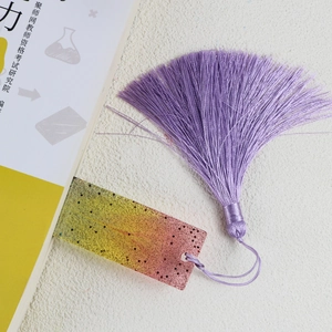 Detail of gradient resin bookmark with glitter and a soft purple silk tassel