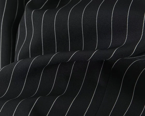 Gros plan sur un tissu noir à rayures blanches révélant une texture sergé et un fini satiné