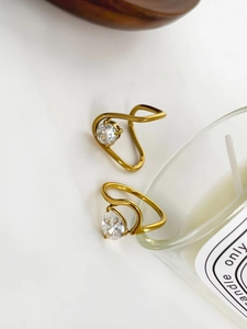 Macro shot of gold-plated geometric rings with zircon stones and wavy band details