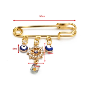 Golden evil eye and ship wheel brooch pin dimensions showing 50mm length and details