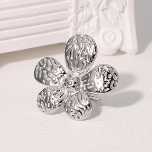 Macro detail of silver flower ring with textured hammered finish and open design
