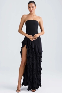 Détail de la fente haute et de l'élégant ourlet à volants d'une robe de soirée noire