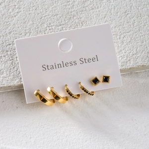Set of three gold stainless steel earrings with black zircons on display card
