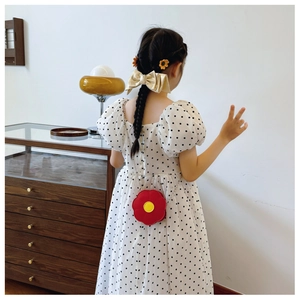 Rear view of a girl wearing a red sunflower-shaped bag and polka dot dress in high quality