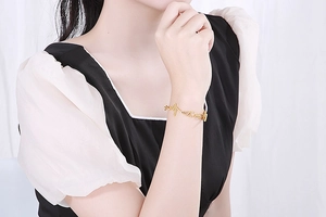 Macro view of golden heartbeat pulse bracelet with chain on model wrist