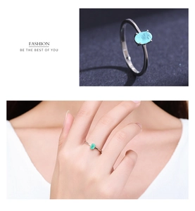 Macro detail of oval light blue gemstone ring in silver setting with model hand view