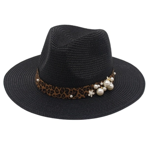 Detail of black straw hat featuring leopard print band with white pearls and small floral accent