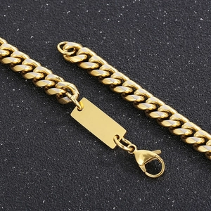 Macro shot of gold Cuban link chain with polished rectangular pendant and lobster clasp