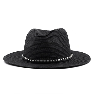 Close-up of black straw fedora hat featuring a stylish silver studded leather band detail