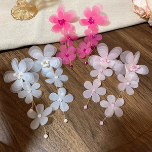 Detailed close-up of chiffon floral tassel earrings in rose, white and pink fabric colors