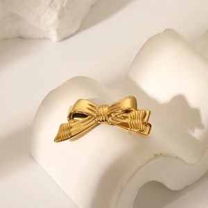 Detail einer glänzenden goldmetallenen Haarklammer mit Textur auf minimalistischem Sockel