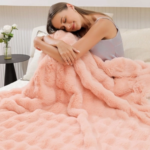 Close-up of pink faux rabbit fur blanket showing thick texture and soft plush feel