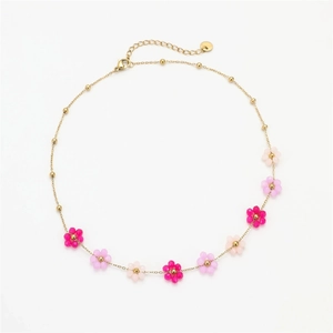 Elegant gold chain necklace featuring colorful floral beads in shades of pink on white background