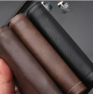 Close-up of premium leather texture and stitching on business wallets in black and brown