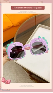 Detail view of purple dinosaur frames with green spikes on toddler sunglasses