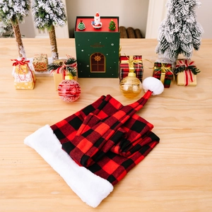 Classic red and black buffalo plaid Christmas hat with white plush trim on a wooden table