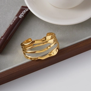 Détail d'un bracelet ouvert multicouche en acier inoxydable 18K avec texture ondulée