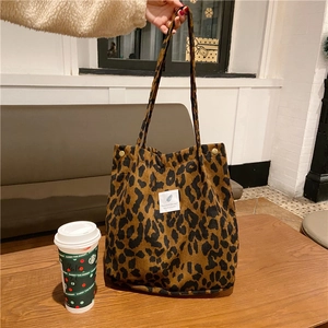 Detail view of leopard print corduroy tote bag with white label and snap button closure