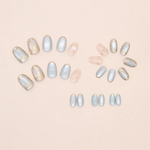 Close-up of cat-eye press-on nails with golden flower, pearls and glitter details