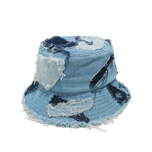 Detail view of distressed light blue denim bucket hat with patchwork and frayed edges