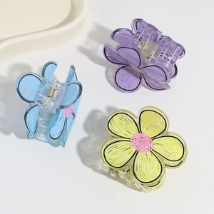 Detail of candy-colored flower hair claws in purple, blue, and yellow with metal spring