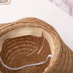 Detailed interior of handmade straw sun hat featuring adjustable strap and sweatband