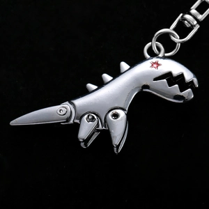 3D metallic dinosaur keychain with silver finish and red star detail on black background