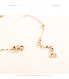 Detail of rose gold heartbeat bracelet with lobster clasp and smiley heart pendant