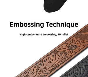 Detail of western cowhide belt showing 3D embossed floral patterns in black and brown