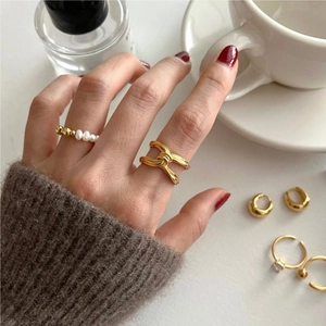 Detailed view of 925 sterling silver knotted ring and gold accessories in cozy setting