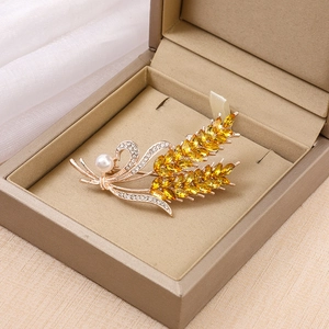Golden crystal wheat ear brooch with yellow marquise stones and pearl in a jewelry box