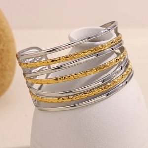 Gros plan détaillé du bracelet manchette multicouche doré et argenté texturé