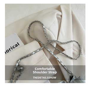 Detail of silver metal chain strap woven with grey leather and a decorative textured ball