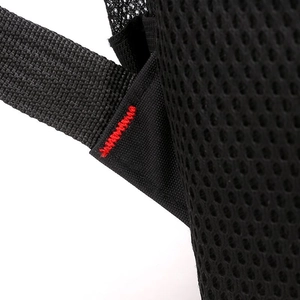 Detail of black travel backpack showing red reinforced stitching and breathable mesh fabric