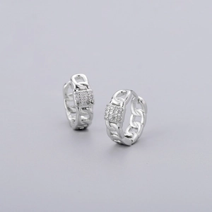 Macro detail of silver hoop earrings with chain texture and micro-pave zircon crystals