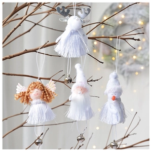 Detail of four white plush Christmas ornaments with bells hanging on rustic branches