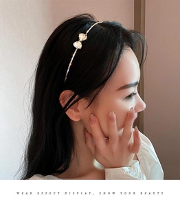 Detail view of a slim gold headband with sparkling rhinestones and a delicate bow tie
