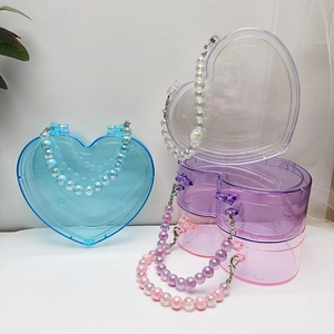 Makroaufnahme von herzförmigen Perlen-Aufbewahrungsboxen in Blau, Lila, Klar und Rosa