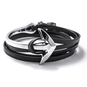 Close-up of multi-layer black braided leather bracelet with silver metal anchor clasp