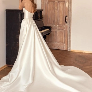 Elegant white satin strapless wedding dress with backless design and long train detail