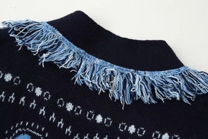 Close-up of dark blue knit cardigan collar with geometric patterns and fringe detail