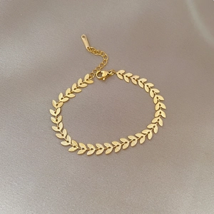 Minimalist golden titanium steel leaf chain bracelet on elegant grey silk texture background