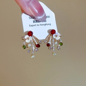 Detailed macro view of vintage gold-plated floral earrings with red gems and pearls