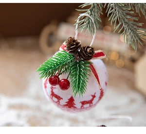 Close-up of red and white plaid Christmas ball with pine cones and berries on tree
