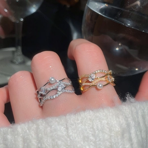 Close-up of elegant 18k gold plated wavy rings featuring pearls and pavé set zircons
