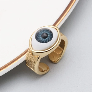 Detailed view of evil eye palm ring with blue zircons on white ceramic plate